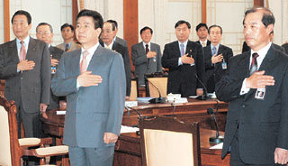 노무현 대통령(가운데)이 20일 청와대에서 국정과제회의를 시작하기 전 국민의례를 하고 있다. 이날 회의에서는 과학기술부 장관을 부총리로 승격하는 것을 골자로 한 과기부 개편방안이 확정됐다.-박경모기자