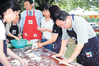 영남대 박운석 교수(가운데)와 노장시 교수(오른쪽)가 교내 축제기간 중 야외음식점에서 학생들과 함께 음식을 준비하고 있다.-사진제공 영남대