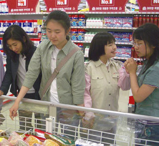 22일 경기 성남시 분당의 한 쇼핑몰에서 정신지체장애 학생이 할인매장에서 물건을 사고 영수증을 받아 오는 과제를 해낼 수 있도록 영덕여고 학생들이 돕고 있다.-김상훈기자