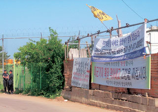 26일 캠프 험프리스 미군기지 확장으로 25만평이 수용될 예정인 경기 평택시 팽성읍 대추리 마을 입구. 미군기지 확장을 반대하는 현수막이 내걸린 가운데 경찰이 기지 외곽경비를 서고 있다.-평택=남경현기자