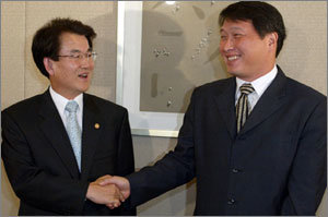 강철규 공정거래위원장(왼쪽)과 최태원 SK 회장이 31일 낮 서울 중구 명동 은행회관 뱅커스클럽에서 오찬을 갖기에 앞서 악수를 하며 활짝 웃고 있다. 박주일기자