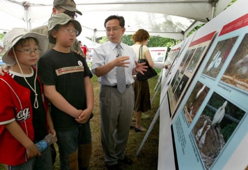 '황새사랑 축제가 3일 충북 청원군 한국교원대에서 열린 가운데 황새복원센터 박시룡 교수(우측 두번째)가 관람객들에게 황새 복원과정이 촬영된 사진을 설명해 주고 있다. 청원=연합