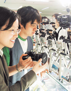 전자상가의 디지털 카메라 매장을 찾은 고객이 진열된 제품들을 살펴보고 있다. 전문가들은 디지털 카메라를 살 때는 화소수나 가격에 집착하기 보다는 자신의 용도에 적합한 제품을 골라야 후회가 적다고 조언했다.사진제공 테크노마트