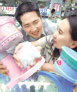 여름용 간식을 만들 수 있는 빙수기, 아이스크림제조기, 믹서 등 이색 가전제품이 인기다. 소비자가 빙수기로 얼음을 갈아보고 있다.사진제공 테크노마트