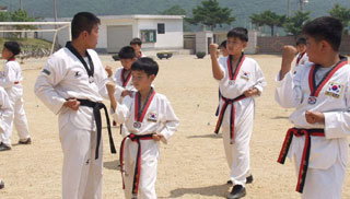 21일 인천 백령도 북포초교에서 해병대 흑룡부대 장병들이 어린이들에게 태권도를 가르치고 있다.-인천=연합