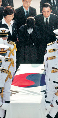 26일 오후 인천국제공항에 도착한 고 김선일씨의 시신을 경찰의장대가 운구하고 있다. 뒤로 오열하는 여동생 정숙씨(가운데)와 반기문 외교통상부 장관(오른쪽)의 모습이 보인다.-영종도=원대연기자