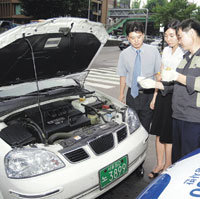 GM대우차 순회정비봉사반 회원들이 고객에게 간단한 차량 점검 요령을 설명하고 있다. 사진제공 GM대우자동차