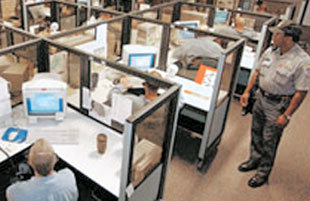 미국 오리건주의 스네이크 리버 교도소에 있는 콜센터에서 교도관의 감시 아래 전화상담에 열중하고 있는 재소자들.-사진제공 USA투데이