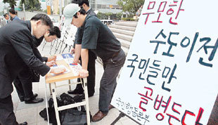 일부 서울 시민들이 9일 오후 광화문에서 열린 수도이전 반대 서명운동에 참여하고 있다. 이 서명운동은 보수성향 시민단체인 국민행동본부가 주관했다.-연합