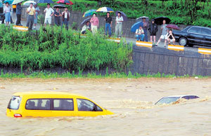 16일 수도권을 비롯해 중부지방에 시간당 최고 50mm의 집중호우가 쏟아져 도로가 침수되는 등 피해가 잇따랐다. 충북 청주시 무심천 하상도로에 주차돼 있던 차량들이 갑자기 불어난 물에 잠겨 떠내려가고 있다.-사진제공 충청일보