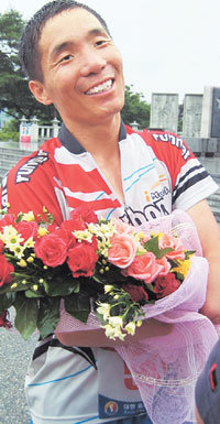 ‘대한민국 종단 울트라마라톤대회’에서 공동 8위를 차지한 김영갑씨가 축하 꽃다발을 안은 채 미소짓고 있다.-임진각=김성규기자