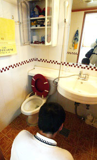 18일 오후 서울 마포구 노고산동 유영철씨의 오피스텔에서 유씨가 “출장마사지사들을 살해했다”고 진술한 화장실을 경찰관이 살펴보고 있다.-원대연기자