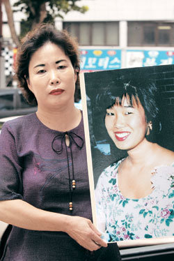 32년 전 입양 보낸 딸을 찾고 있는 김옥희씨(56·여)가 5일 오전 ‘2004 세계한인입양인대회’가 열리고 있는 서울 소피텔앰배서더 호텔 앞에서 딸 김수미씨(33)의 사진을 붙인 피켓을 들고 서 있다.- 전영한기자