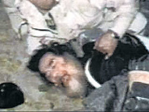 지난해 12월 13일 이라크 북부도시 티크리트 인근 시골의 한 농가 땅굴에서 사담 후세인 전 대통령이 붙잡히는 모습.- CNN TV 촬영