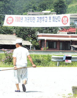 ‘갈등, 희비, 혼란….’ 수도 이전 지역의 최종 발표(11일)를 앞두고 충남 연기군-공주시(장기면) 일대는 수용 여부에 따라 희비가 엇갈리고 있다. 9일 수용 가능성이 높은 연기군 남면 양화2리에 수도 이전을 반대하는 플래카드가 걸려 있다. -원대연기자