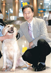 강호 인천공항 세관 마약탐지과장이 노련한 마약탐지견인 ‘덴버’를 쓰다듬어주고 있다.-원대연기자