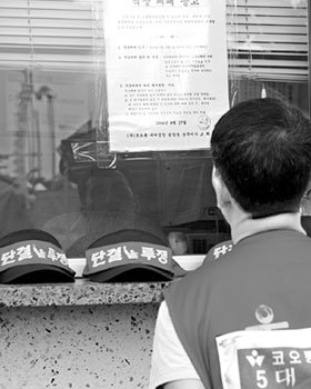 17일 경북 구미시 코오롱 구미공장에서 이 회사의 노조원이 직장폐쇄 공고를 읽고 있다. 코오롱은 파업 57일째가 되는 18일 오후 3시를 기해 스판덱스 등 일부 사업장을 제외한 사업장에 대해 직장폐쇄 조치를 단행키로 했다고 밝혔다.구미=연합