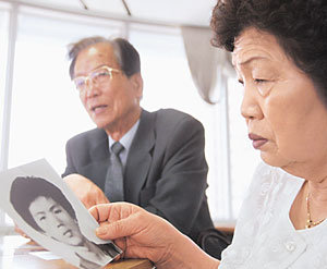 ‘녹화사업’ 당시 고문을 견디다 못해 자살한 한희철씨의 어머니 김인련씨가 21년 만에 명예 졸업장을 받게 된 아들의 옛 사진을 보며 회한에 잠기고 있다. 왼쪽은 아버지 한상훈씨.-김재영기자
