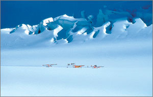 서던알프스 산맥의 계곡 하나를 완벽하게 뒤덮은 '얼음의 바다' 태즈먼 빙하. 주름지듯 깊이 팬 빙하의 얼음산 아래로 스키플레이트를 달고 빙하의 설면에 착륙한 스키플레인과 관광객들이 보인다.