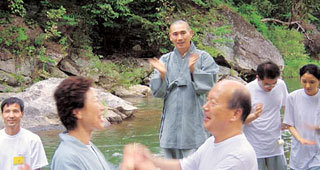 마가 스님(가운데)이 22일 저녁 마곡사 개울가에서 휴식시간에 게임을 하며 즐거운 시간을 보내는 부부들을 보며 박수를 치고 있다. -공주=지명훈기자