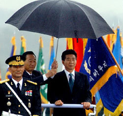 지난해 10월 1일 국군의 날 행사 때 조영길 당시 국방부장관이 사열차량에서 노무현 대통령에게 우산을 씌워주고 있다. -동아일보 자료사진
