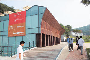 한길사 김언호 사장이 4일 개관한 복합문화공간 북하우스 전경. 검게 물들인 긴 나무들을 촘촘히 이어 붙여 외벽을 감쌌다. 700여 평 규모인 북하우스는 전시 공연 공간과 책을 읽을 수 있는 옥외 공간, 레스토랑을 갖추고 있다. 사진제공 헤이리조직위원회