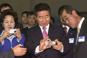 노무현 대통령(가운데)이 6일 부산에서 열린 ‘국제전기통신연합(ITU) 텔레콤 아시아 2004’ 개막식에 참석해 삼성전자 전시장을 둘러보고 있다.-박경모기자