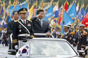 노무현 대통령(가운데)이 1일 충남 계룡시 계룡대에서 열린 제56주년 국군의 날 기념식 열병행사에서 윤광웅 국방부 장관(왼쪽)과 함께 각 군을 사열하고 있다. -계룡=박경모기자