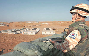 이라크 평화재건활동을 지원하기 위해 북부 아르빌에 파병된 한국군 자이툰부대의 주둔지에서 부대원이 태극 마크를 단 군복을 입고 경계를 서고 있다. -아르빌=연합