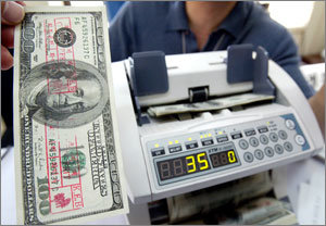 서울지방경찰청 외사과 관계자가 19일 경찰에 적발된 초정밀 위조지폐를 구형 위조지폐감식기에 통과시키는 시험을 하고 있다. 대량 유통된 것으로 확인된 이 위조지폐는 시중은행 지점들에 있는 구형 위폐감식기로는 식별할 수가 없다. 연합