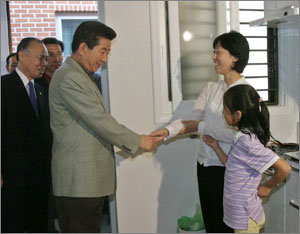 노무현 대통령(가운데)이 19일 오후 서울 강서구 화곡본동의 매입 임대 다가구주택에 입주한 주민들을 방문했다. -박경모기자