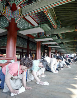 내년 경복궁 경회루 공개를 앞두고 19일 오후 경회루 마룻바닥 길들이기 행사에 참가한 자원봉사자들이 물걸레로 깨끗이 청소하고 있다.안철민기자 acm08@donga.com