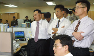 21일 오후 신행정수도건설추진위원회 소속 직원들이 서울 세종로 정부중앙청사 내 사무실에 모여 헌법재판소의 결정을 굳은 표정으로 지켜보고 있다. -연합