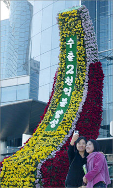 한국무역협회가 연간 수출 실적 2000억달러를 돌파한 22일 서울 강남구 코엑스 주변에 국화꽃으로 장식한 기념탑을 세웠다. 무역협회는 올해 수출 실적을 기념하는 ‘국화페스티벌’을 다음달 5일까지 열기로 했다. 변영욱기자