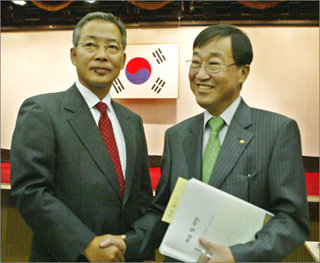 국민은행 강정원 신임 행장(왼쪽)과 김정태 전 행장이 29일 서울 여의도 국민은행 본점에서 열린 임시 주주총회가 끝난 뒤 악수하고 있다. 권주훈기자