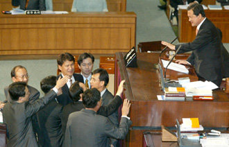 “마이크 왜 껐나” 항의12일 국회 본회의장 의장석 앞으로 여야 의원들이 몰려나와 김덕규 부의장에게 의사진행 발언을 요청하며 뒤엉켜 있다. 이날 본회의 일시 중단사태는 한나라당 최구식 의원의 대정부질문 도중 마이크가 꺼지는 바람에 벌어졌다. 전영한기자