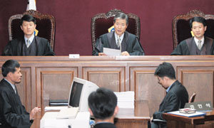 서울고법 형사10부 법정에서는 ‘재판은 당사자들에게 재판의 내용과 결과를 잘 알려줄 수 있도록 진행돼야 한다’는 기본적인 사실을 실감할 수 있다. 재판장은 재판 중간중간에 피고인뿐 아니라 방청객들을 위해서도 “그 뒤까지 잘 들립니까”라고 묻곤 한다. 가운데가 손기식 부장판사. 박주일기자