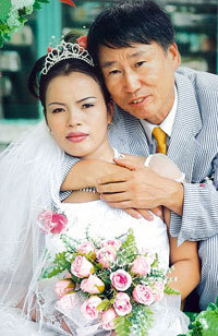 10월 베트남에서 결혼식을 올린 프로기사 서봉수 9단(오른쪽)과 베트남 출신의 신부 람티히 무아 씨.연합