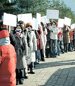 20일 경기 안양시 샘모루초등학교 정문에서 학부모들이 중학교 근거리 배정을 요구하며 시위를 벌이고 있다. 안양=연합