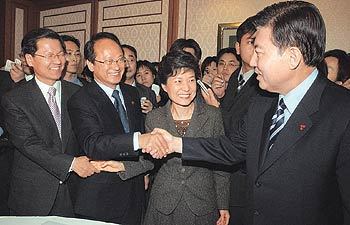 21일 오후 마라톤협상 끝에 내년 정부예산안 등의 연내 처리를 타결지은 열린우리당 이부영 의장(왼쪽에서 두 번째)과 한나라당 김덕룡 원내대표(오른쪽), 한나라당 박근혜 대표(오른쪽에서 두 번째)와 열린우리당 천정배 원내대표가 각각 손을 맞잡고 환하게 웃고 있다.전영한 기자 scoopjyh@donga.com