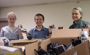 해외주둔 미군에게 전화카드 보내기 운동을 펼치고 있는 브리타니 버그퀴스트 양(왼쪽)과 로비 군(가운데) 남매가 전국에서 배달된 안 쓰는 휴대전화를 정리하고 있다.-사진 제공 cellphonesforsoldiers.com