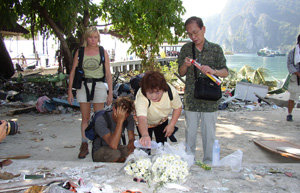 지난해 12월 31일 태국 피피 섬을 찾아 해일에 휩쓸려 사라진 딸이 마지막으로 디뎠던 땅에 국화꽃을 놓고 정화수를 뿌리며 넋을 기리고 있는 한 일본인 부부(오른쪽 두 사람). 푸껫=박형준기자