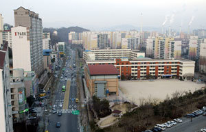 도로를 마주 보고 있는 서울 양천구 신시가지 내 Y초등학교와 아파트 단지. 아파트 단지 주민들은 바로 앞 Y초등학교를 두고 300m 떨어진 다른 초등학교에 배정하는 것은 불합리하다며 관할 교육청에 민원을 제기하고 있다. 박주일 기자