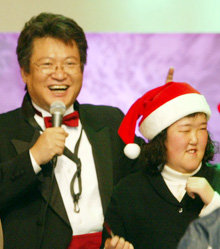 지난해 12월 말 서울 서초구 방배동 CJ홈쇼핑 스튜디오에서 열린 자선음악회에서 우광혁 교수(왼쪽)가 장애가 있는 어린이와 함께 노래를 부르고 있다.  신원건 기자