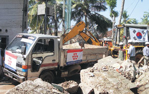 12일 오전 스리랑카 남부 갈 시내에서 코오롱건설의 화물차량들이 태극기를 달고 지진해일 피해 복구작업을 벌이고 있다.