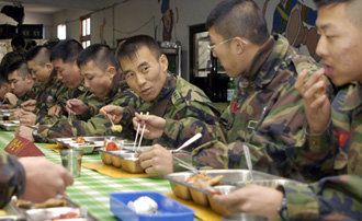 14일 해병대 포항1사단 71대대 식당에서 최병호 대대장(오른쪽에서 세 번째)이 부대원들과 함께 식사하고 있다. 해병대에선 올해 들어 장교와 부사관 병사가 ‘한솥밥 식사’를 하고 있다. 포항=연합