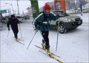 “차보다 스키가 빨라요”16일 40cm가량의 눈이 쌓인 강원 평창군 횡계 지역에서 행인 2명이 차로에서 스키를 타고 있다. 평창=연합