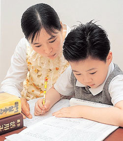 학습지는 꾸준히 하는 것이 중요한만큼 부모는 자녀가 싫증내지 않고 매일 공부할 수 있도록 격려해줄 필요가 있다. 한 학생이 부모와 함께 공부하는 모습. 동아일보 자료 사진