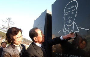 4일 부산 부산진구 초읍동 부산학생교육문화회관 광장에 설치된 의인 이수현 씨의 추모비를 이 씨의 아버지인 이성대 씨가 어루만지고 있다. 옆에는 이 씨의 어머니 신윤찬 씨. 부산=연합