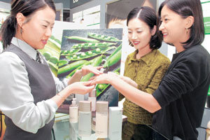 최근 참살이 바람으로 녹두 콩 등 몸에 좋은 곡식을 화장품에 활용하는 사례가 늘고 있다. 서울 한 백화점에 있는 LG생활건강 오휘 매장에서 여성 고객들이 콩을 주재료로 사용한 화장품을 피부에 발라 보고 있다. 사진 제공 LG생활건강